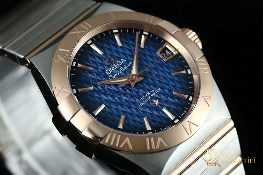 VS Factory Omega Constellation çift renk rose gold smoky blue kabartma eşkenar dörtgen desenli replika saat - 123.20.38.21.03.001 - Kasa Profili ve Kurma Kolu İncelemesi