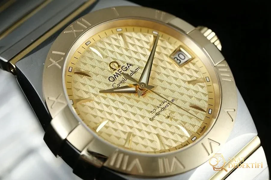 VS Factory Omega Constellation Serisi Baklava Desenli Şampanya Renkli Replika Saat - 123.20.38.21.08.002 - Kasa Profili ve Kurma Kolu İncelemesi